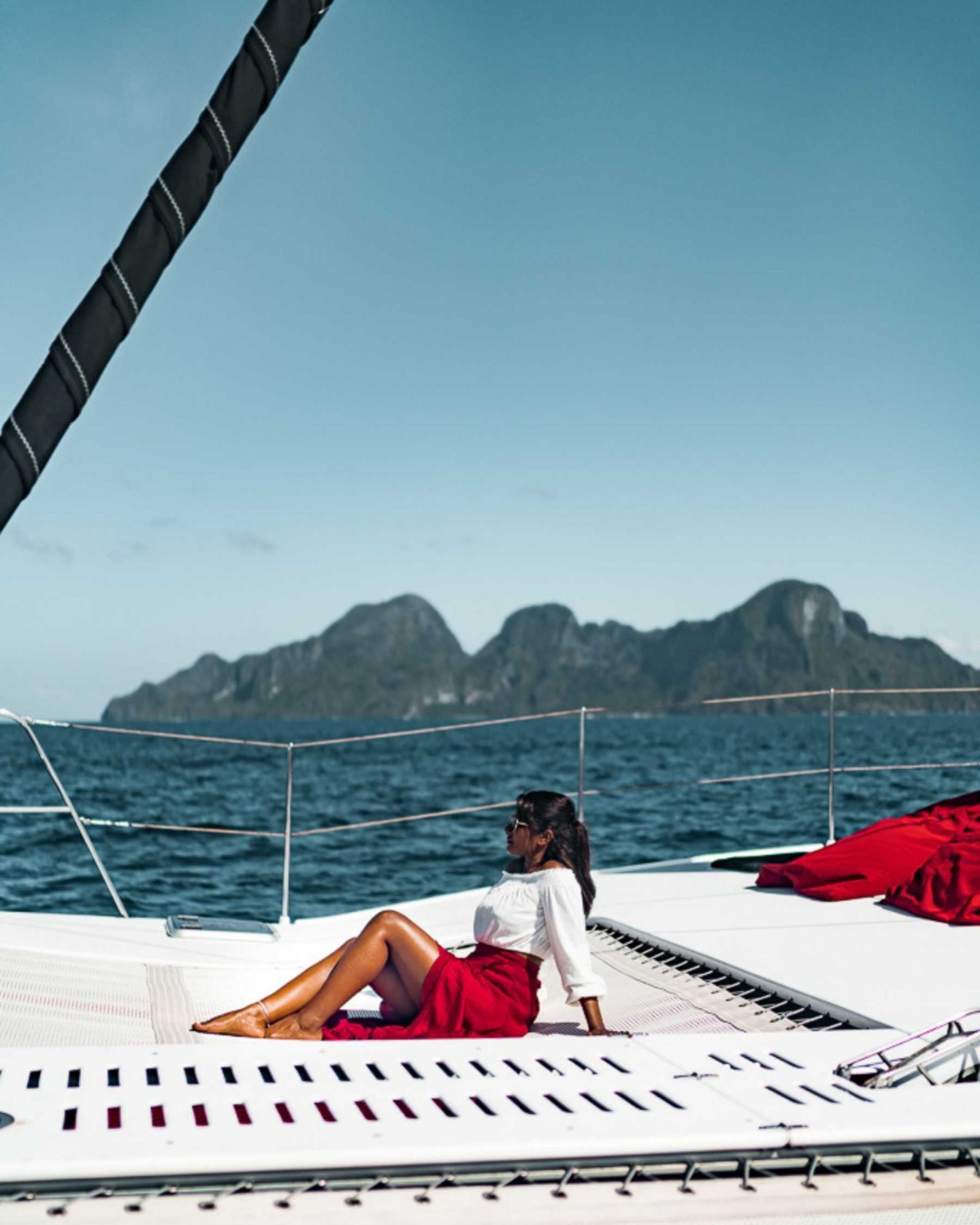 woman in red dress enjoying views from a catamaran
