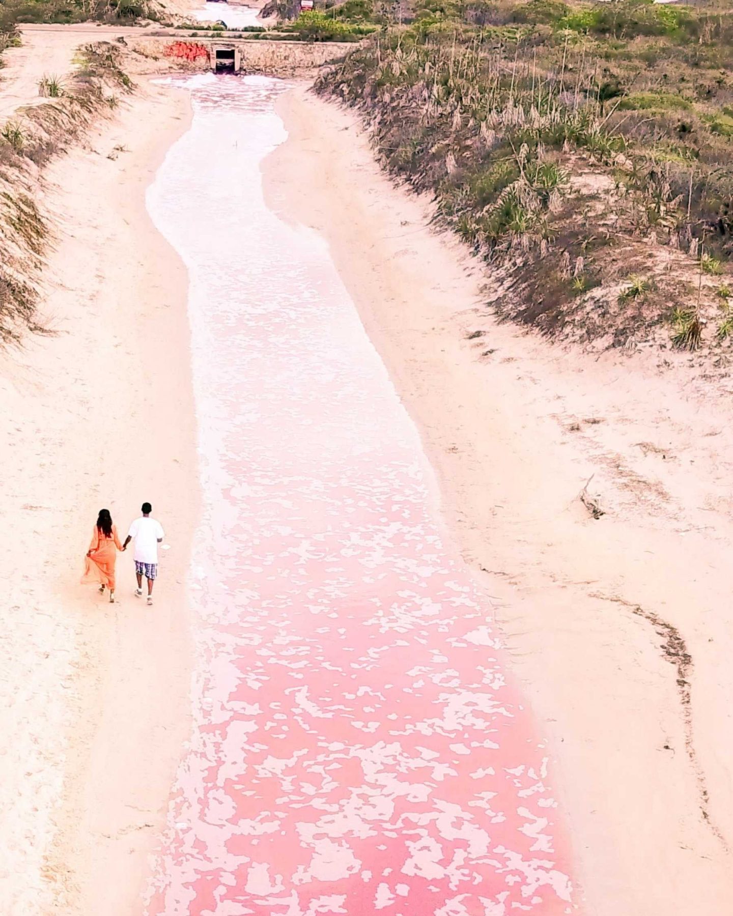 couple enjoying a walk at pink lakes of rio lagartos los coloradas drone view