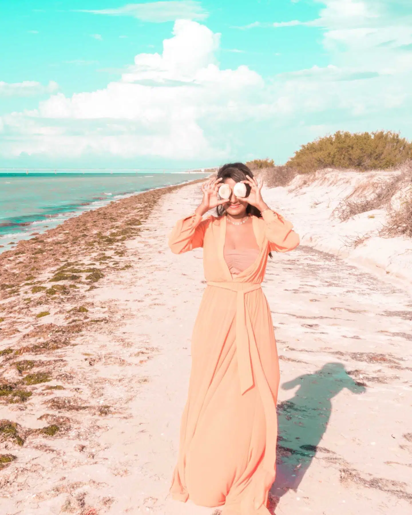 woman playing with seashells at los coloradas rio pink lake in mexico