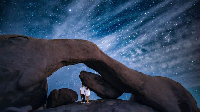 astrophotograph at arch rock in joshua tree national park wewanderlust.co