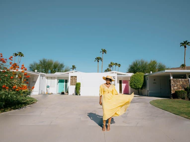 beautiful woman standing in front of teal and pink doors in palm springs california wewanderlust.co