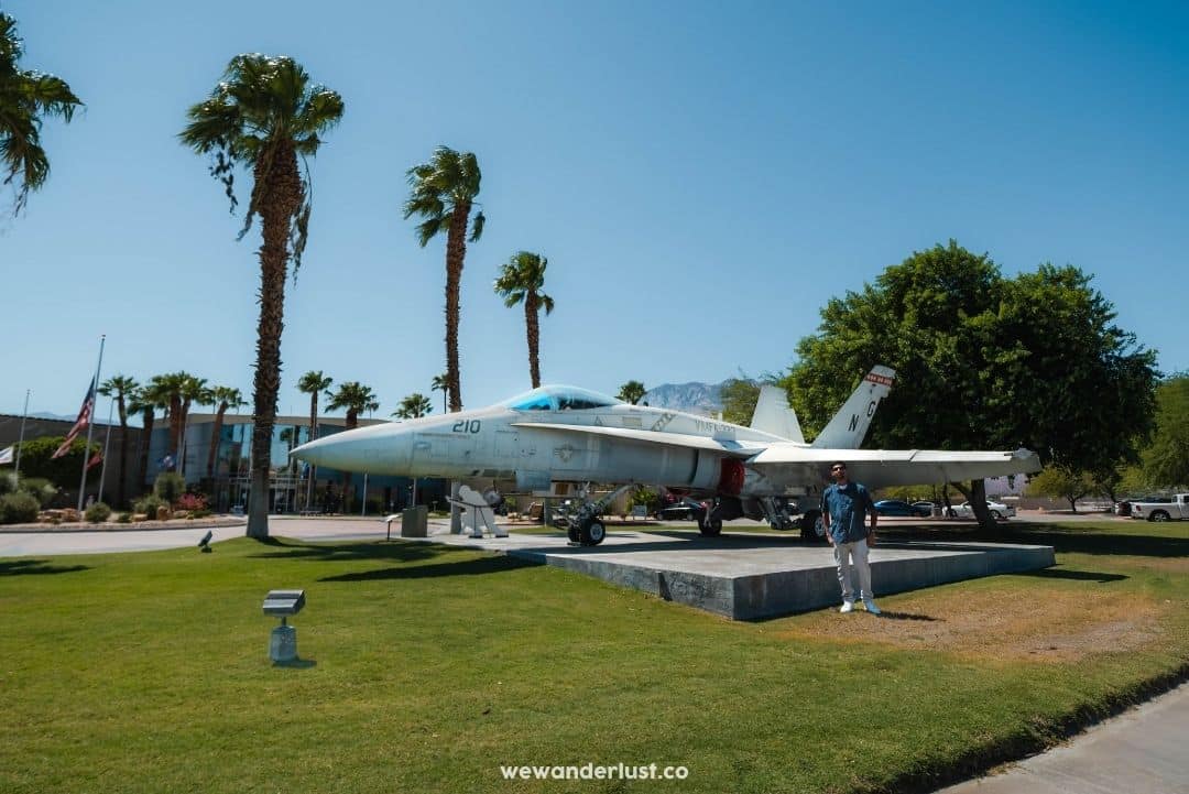 man standing in front of fight jet at palm springs air museum

