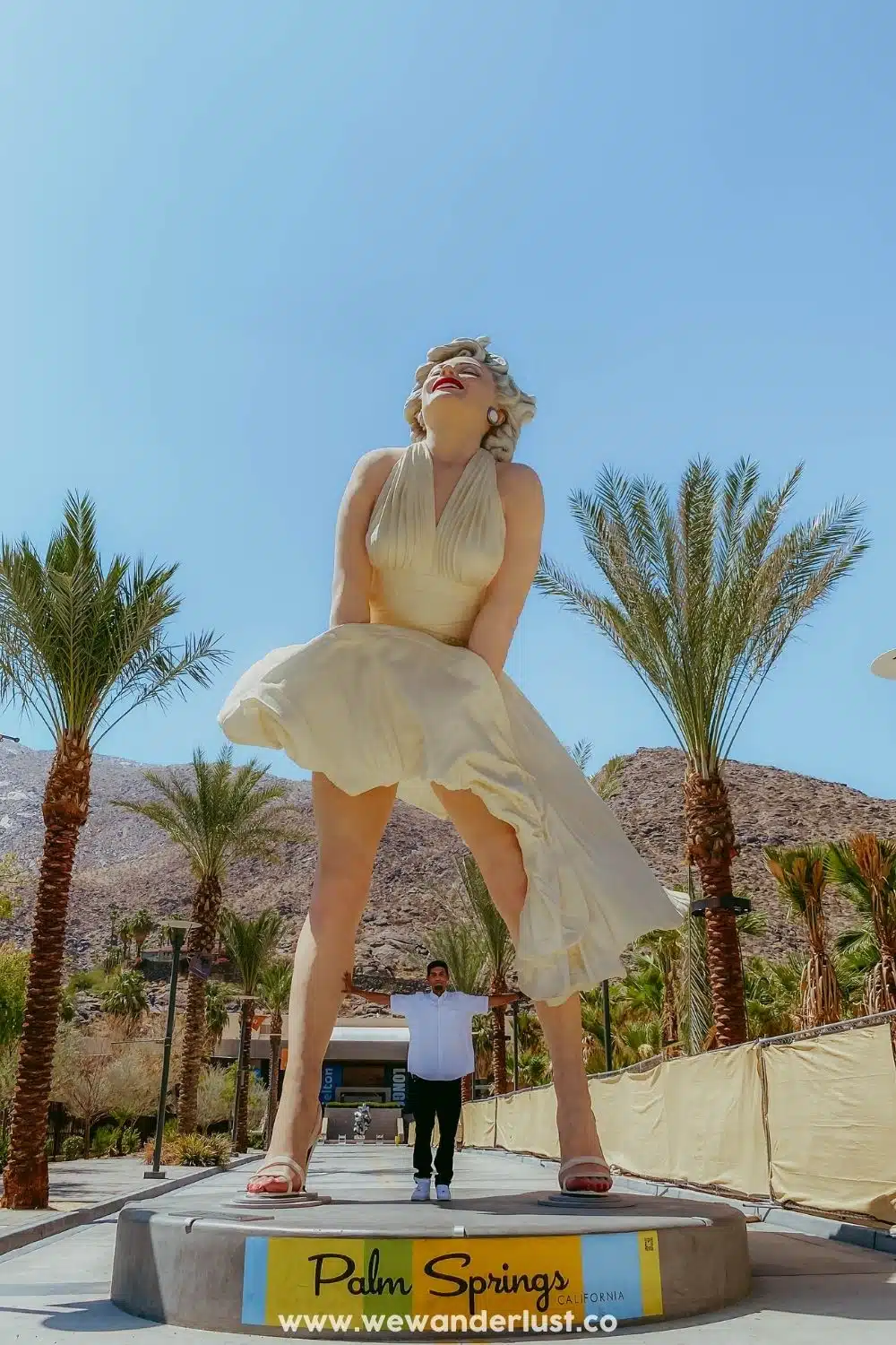 man standing under marilyn monroe statue in palm springs design district