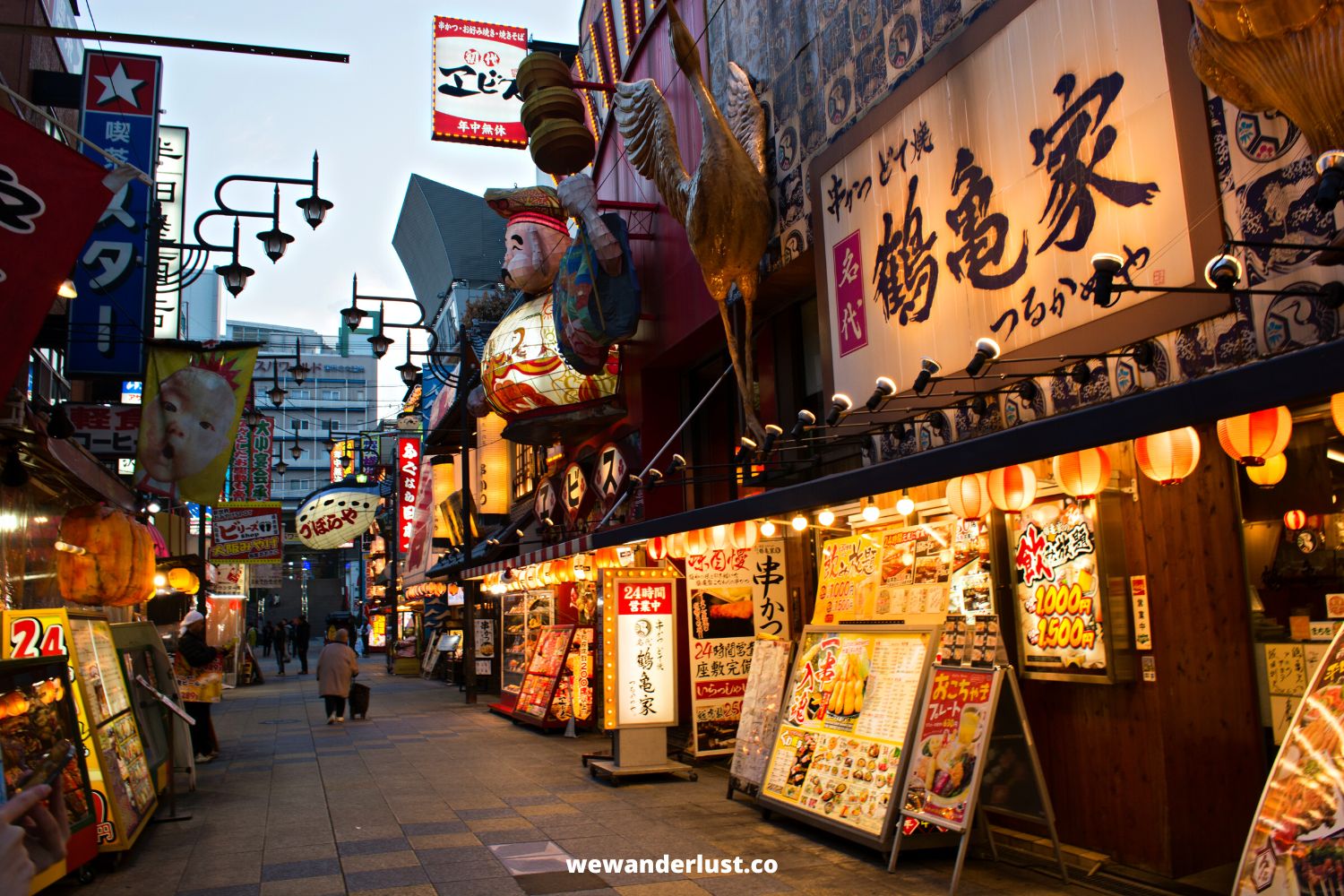 shops in lit up alleyway in japan