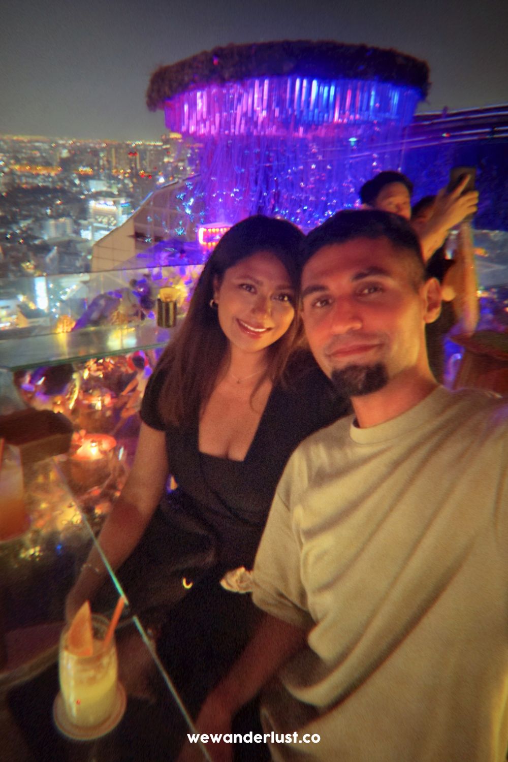 couple sitting at rooftop bar tichuca bangkok
