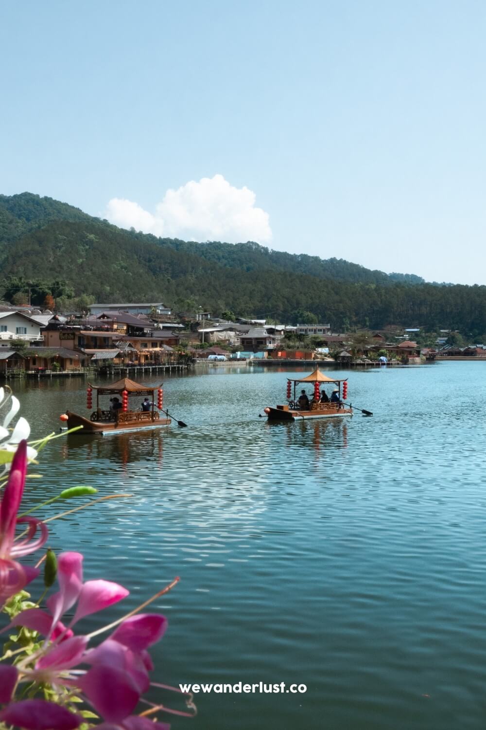 tourists riding boats on lake at ban rak thai