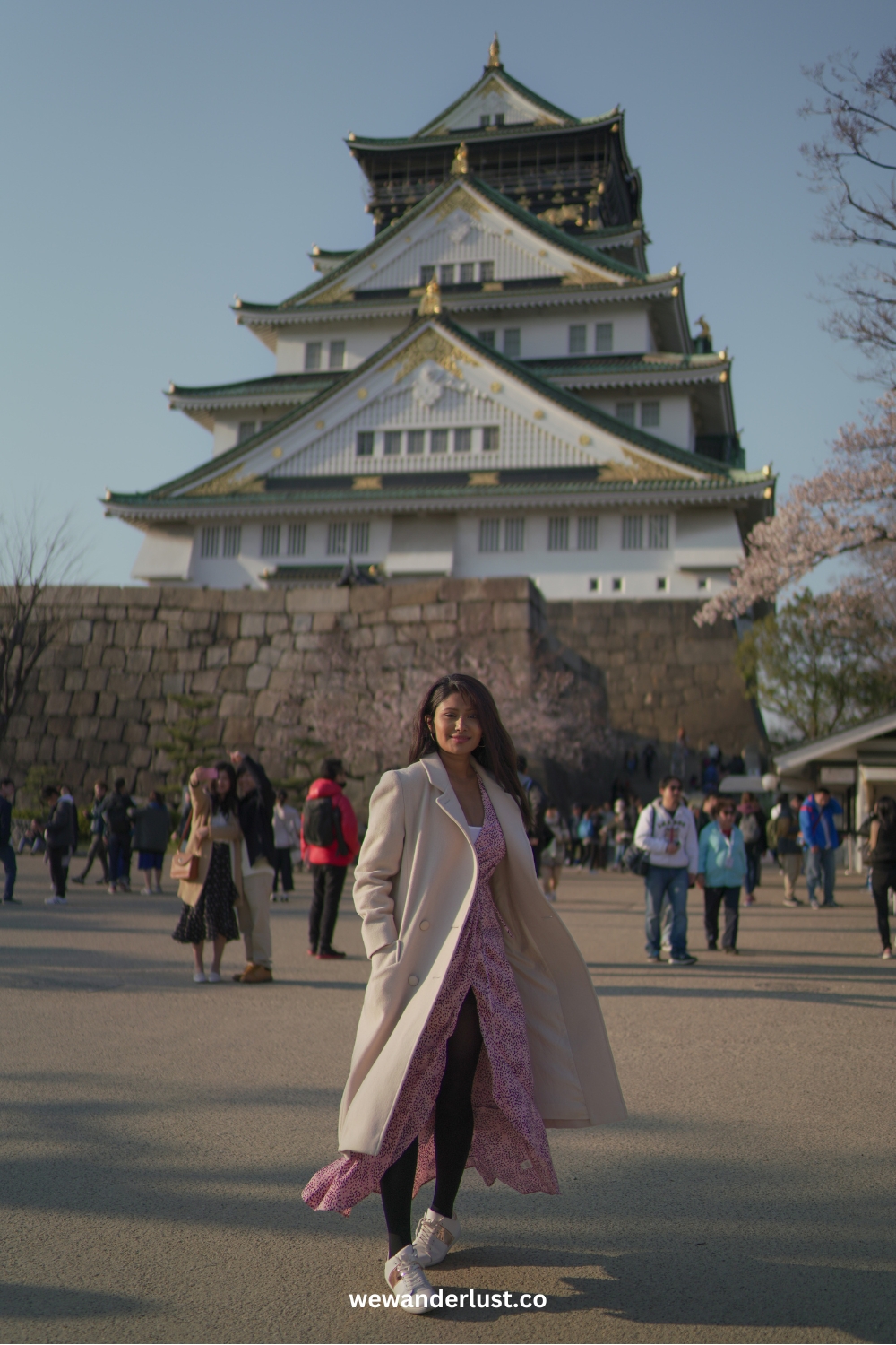 beautiful woman standing in front of osaka castle