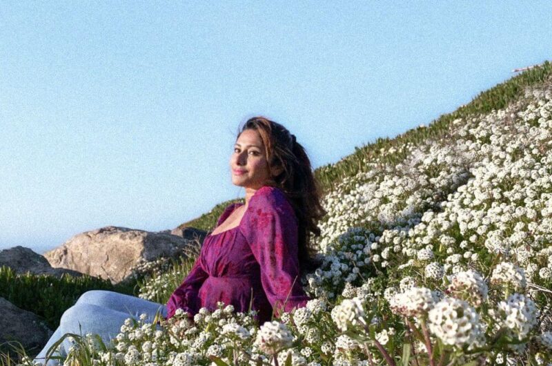 beautiful woman sitting in wildflowers